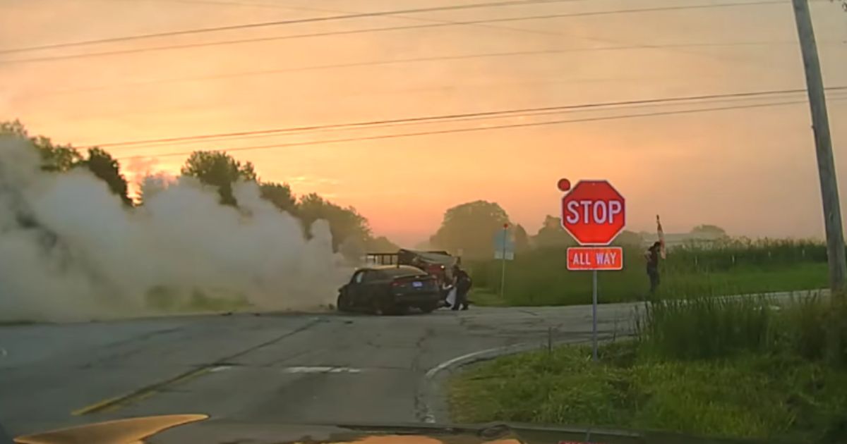 Officers from the police department in the village of Oswego, Illinois, rescue the occupants from a smoldering vehicle at a crash site in the village recently.