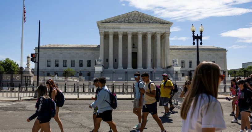 Student tour groups walk past the U.S. Supreme Court Building on Monday.