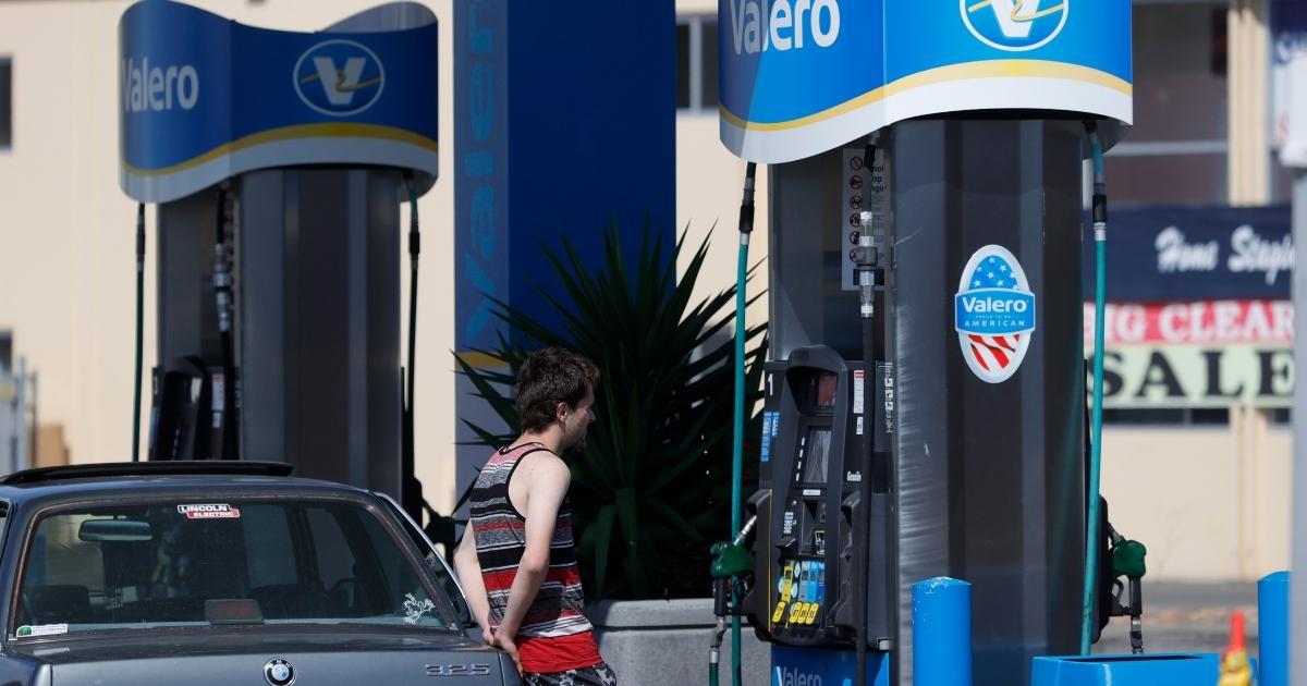 a customer pumping gas at a Valero gas station