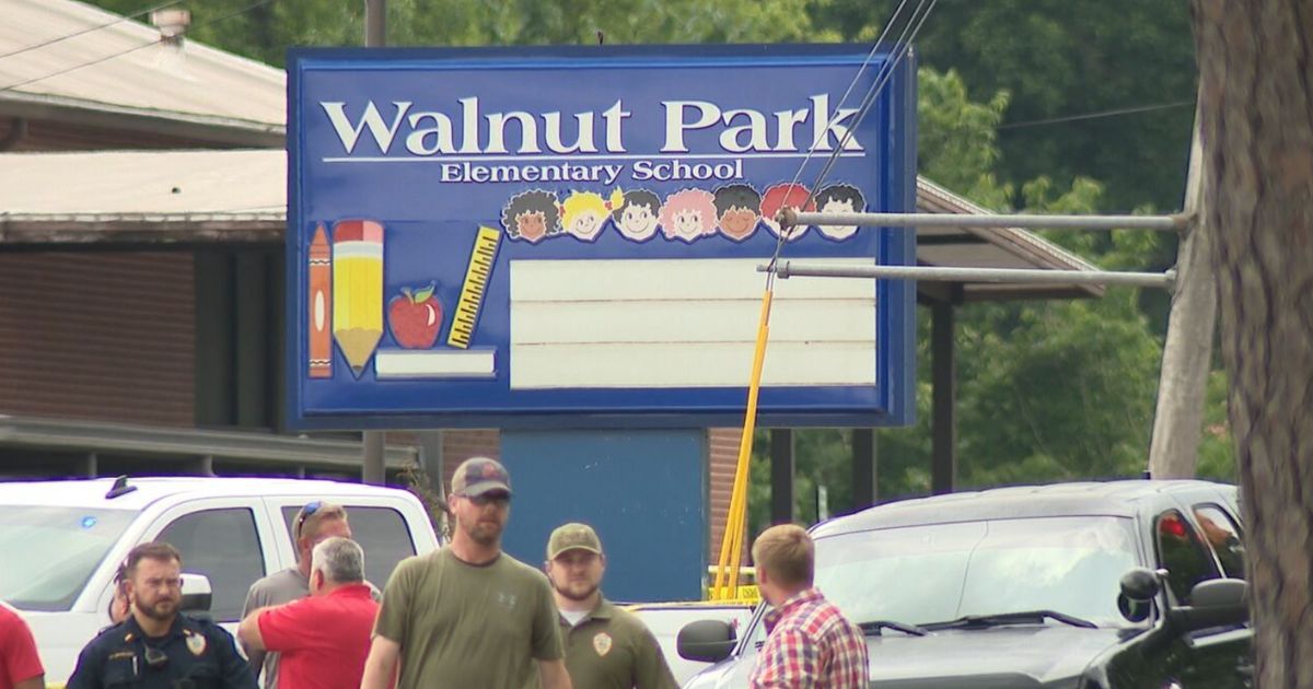 Officers and parents gather outside of Walnut Park Elementary School near Birmingham, Alabama, after a man threatening the school was shot dead outside the building on Thursday.