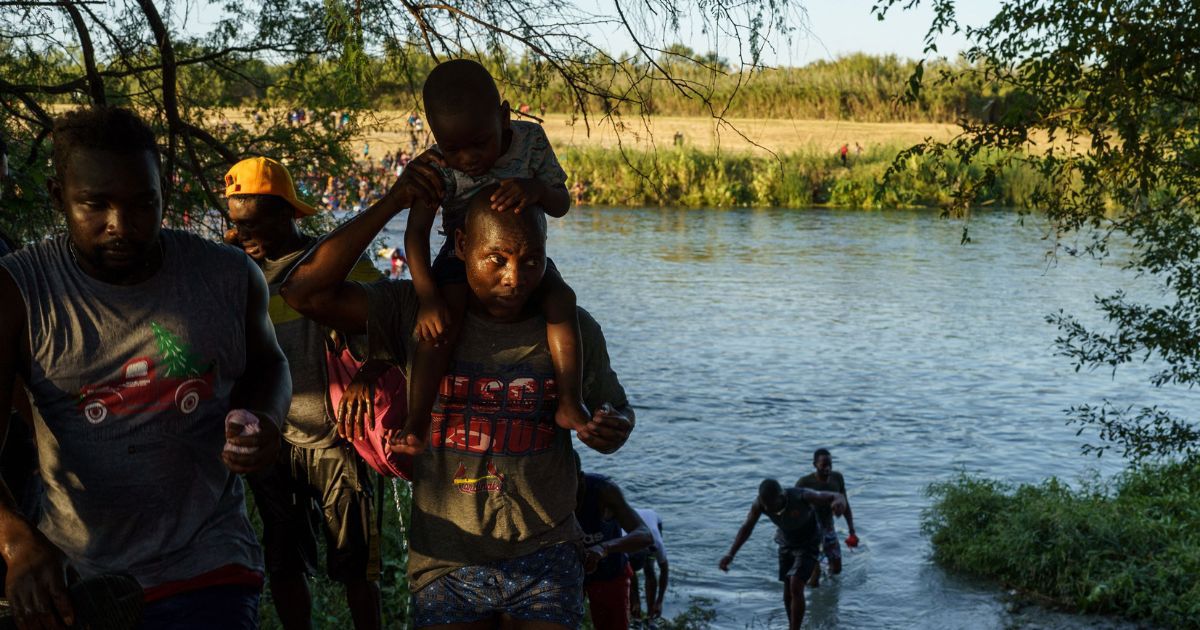 Haitian migrants cross the US-Mexico border at the Rio Grande on September 19, 2021.