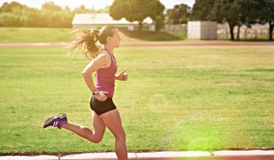 A girl runs on a track in the above stock image.