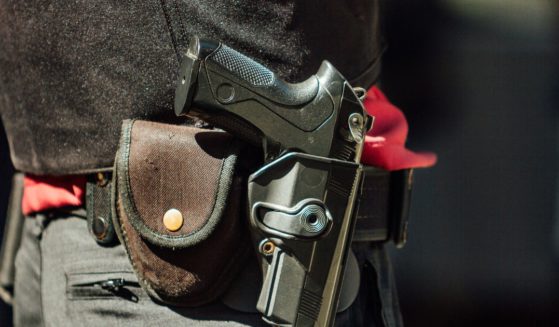 A man carries a gun in a holster in the above stock image.