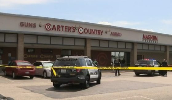 Police cars and crime scene tape mark the site of an attempted robbery at a Houston gun store.