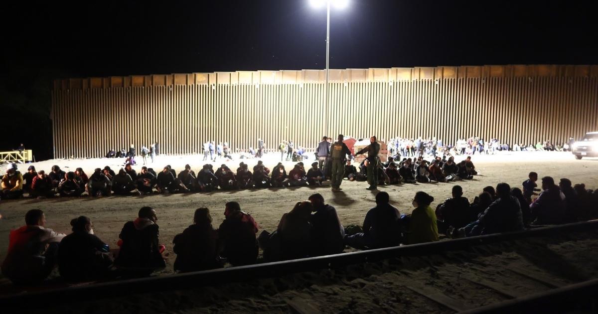 Illegal immigrants wait in the morning to be processed by the U.S. Border Patrol after crossing from Mexico