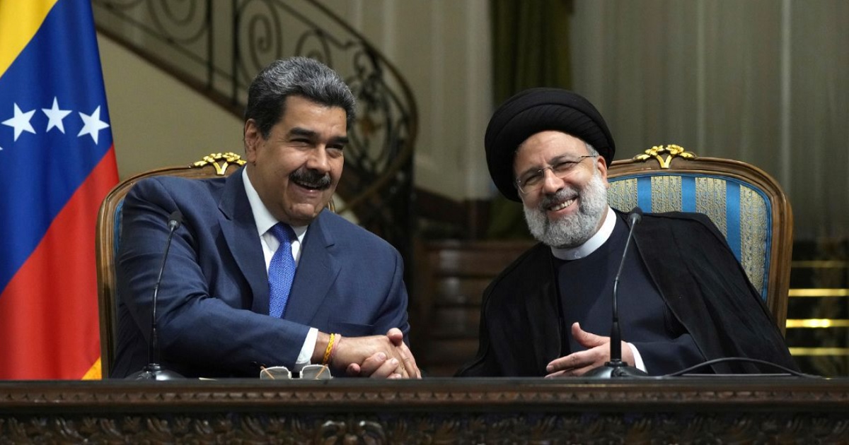 Venezuelan President Nicolas Maduro, left, and Iranian President Ebrahim Raisi, right, shake hands at their news briefing at the Saadabad Palace in Tehran, Iran, on Saturday
