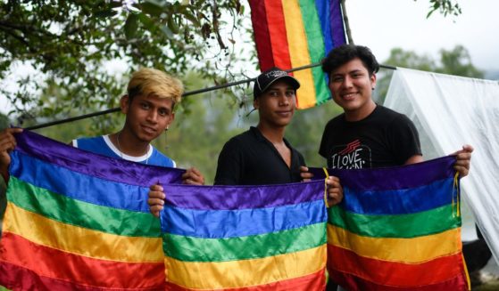 Guatemalan migrants pose with LGBT flags at a makeshift camp in Huixtla, Chiapas state, Mexico, on Wednesday.