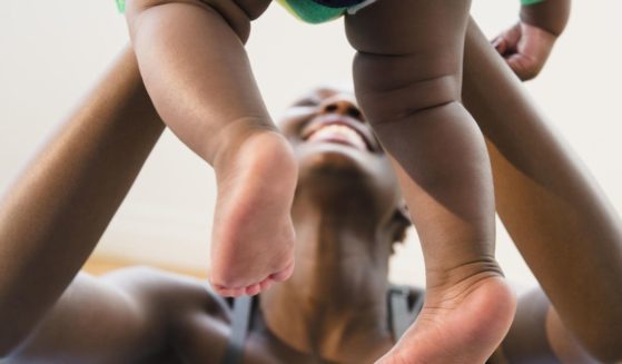 A mother plays with her baby in this stock image.