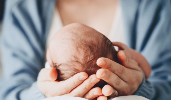 A mother holds her baby in this stock image.