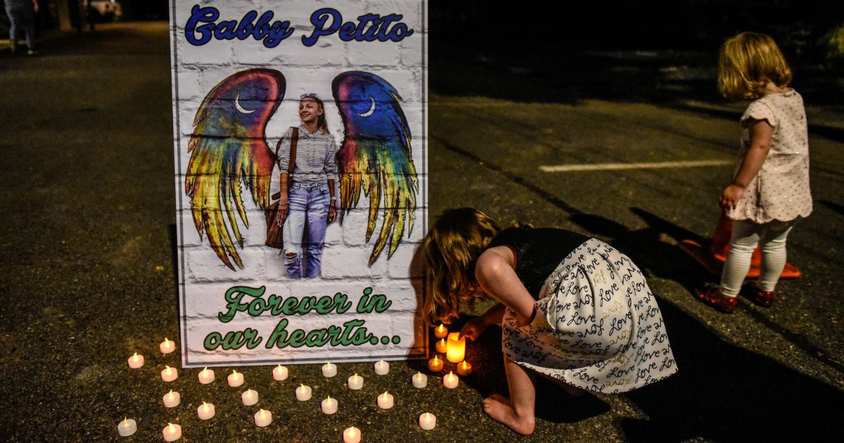 Two children gather at a candlelight vigil on September 24, 2021, to honor the death of Gabby Petito in her hometown of Blue Point, New York.