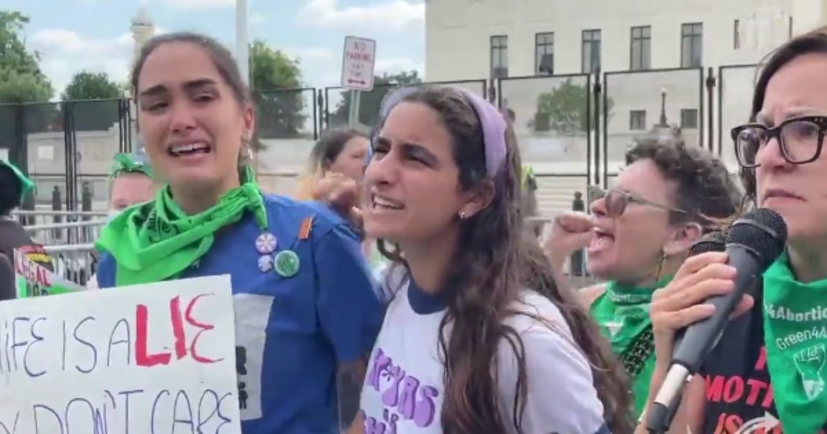 pro-abortion protestors cry outside the Supreme Court building