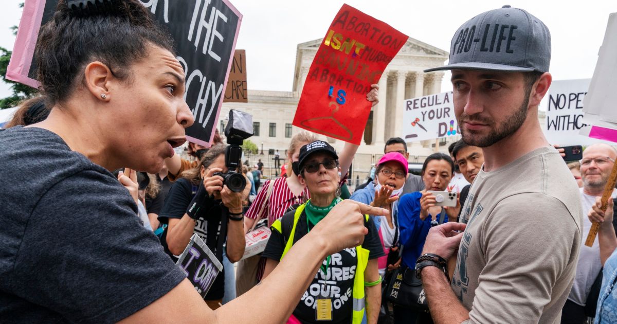 A pro-abortion activist points finger at man wearing a Pro-life hat outside the Supreme Court in Washington, D.C., on May 14.