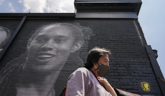 A visitor in the Georgetown neighborhood of Washington walks down an alley past a mural depicting WNBA star Brittney Griner and other American hostages and wrongful detainees who are being held abroad.