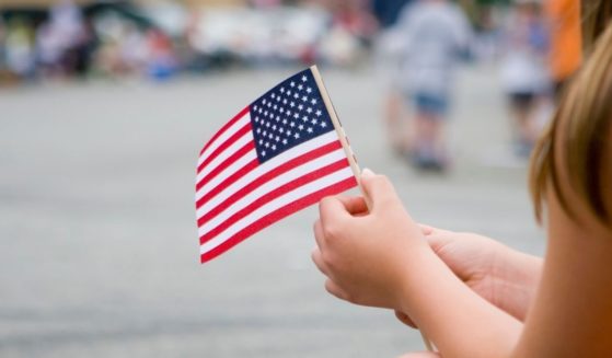 A girl holds an American flag in this stock image.