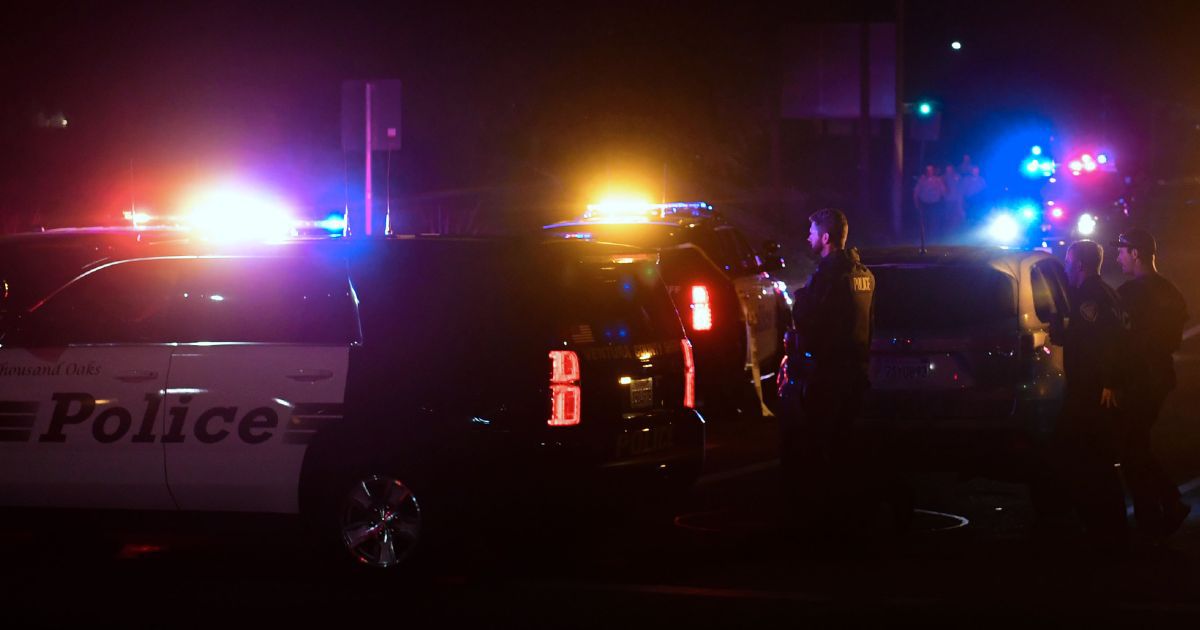 Police officers stand outside of their flashing vehicles after a shooting in Thousand Oaks, California, on Nov. 8, 2018.