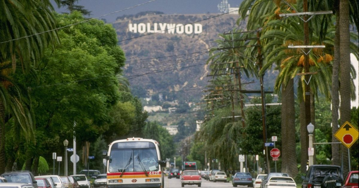 The famous "Hollywood" sign is seen from a street in a Los Angeles neighborhood.