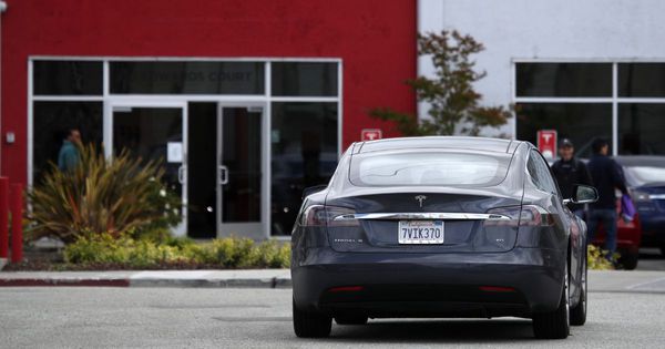 A Tesla Model S drives in the parking lot of the Tesla showroom and service center in Burlingame, California, on May 20, 2019.