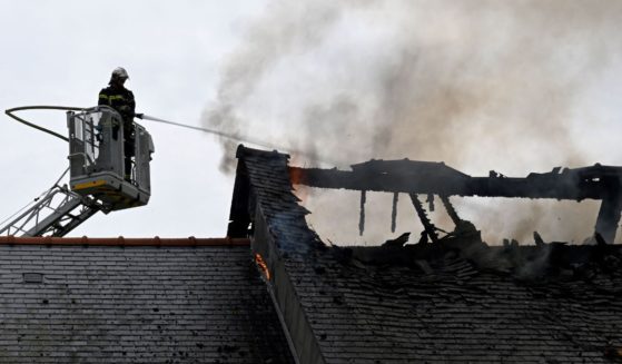 A firefighter in Saint-Symphorien, western France, works to put out a house fire on May 22.