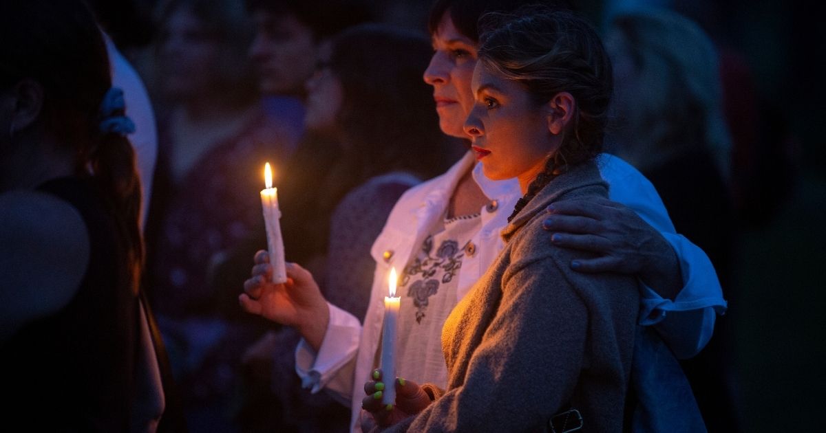 People mourn at a vigil near the scene of a shooting on Thursday in Highland Park, Illinois.
