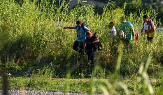 A migrant family illegally enters the United States by crossing the Rio Grande River near Eagle Pass, Texas, on June 30.