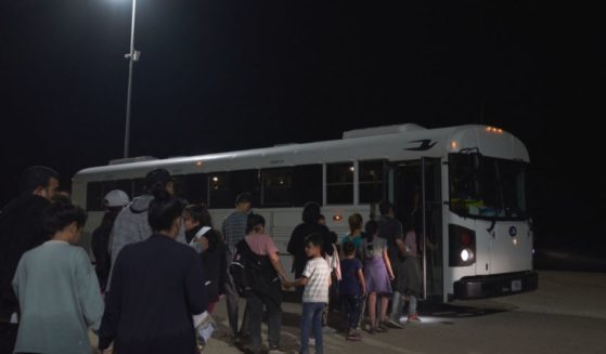U.S. Border Patrol agents direct migrants to a bus for processing after illegally crossing into the United States near Yuma, Arizona, on July 11.