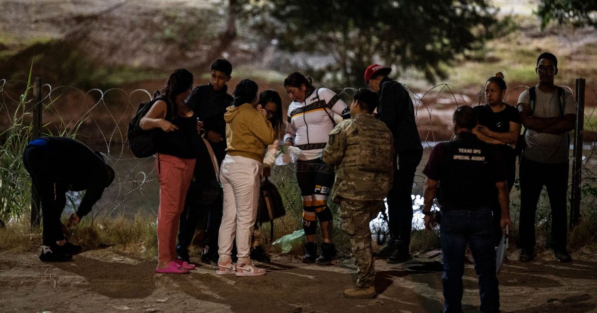 Illegal immigrants are apprehended by Border Patrol agents and National Guard troops in Eagle Pass, Texas, near the border with Mexico, on June 30.