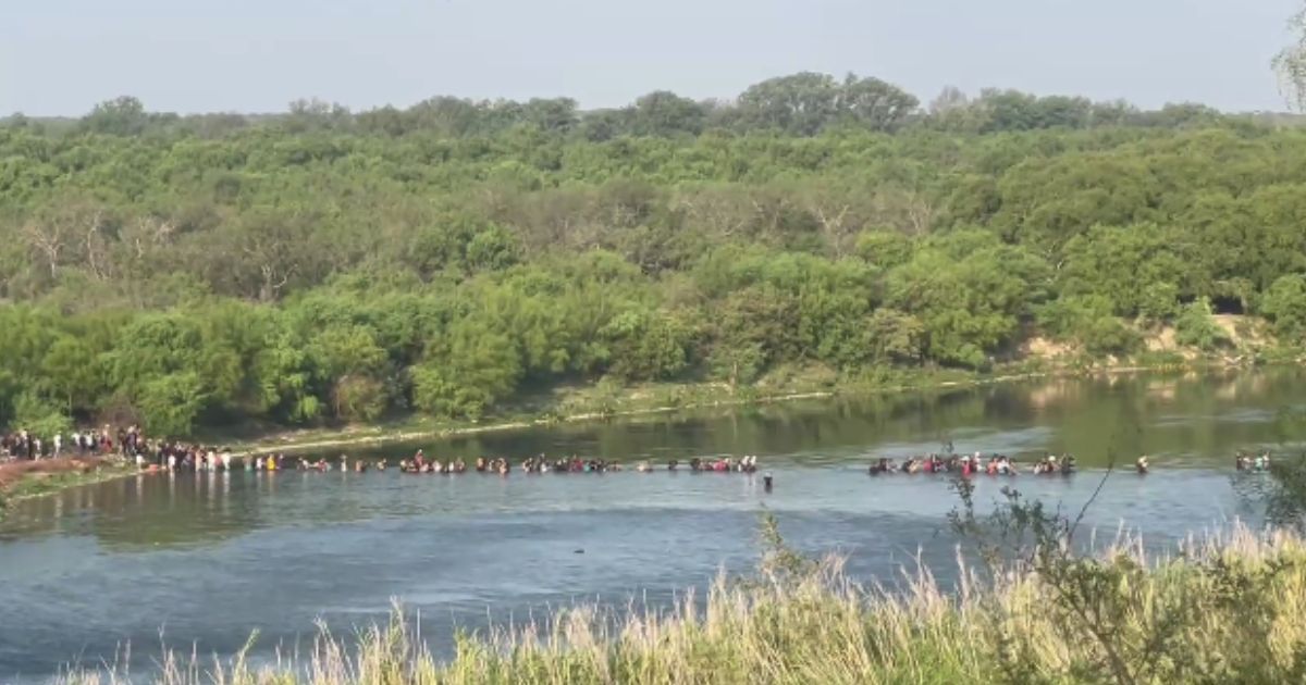 A large group of immigrants crosses the border illegally into Eagle Pass, Texas, early Wednesday morning.