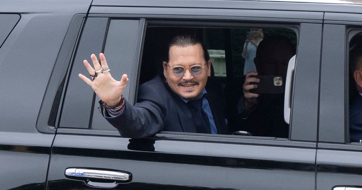 Johnny Depp waves to his fans as he arrives at court on May 27 in Fairfax, Virginia.