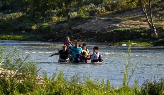 A migrant family from Venezuela illegally crosses the Rio Grande River in Eagle Pass, Texas, at the border with Mexico on June 30.