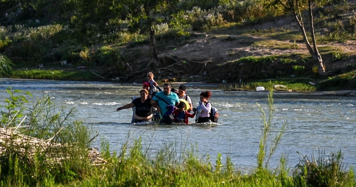 A migrant family from Venezuela illegally crosses the Rio Grande River in Eagle Pass, Texas, at the border with Mexico on June 30.