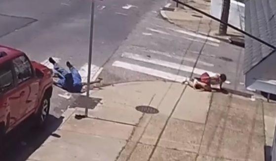 Two men level pistols at each other on a Philadelphia street corner