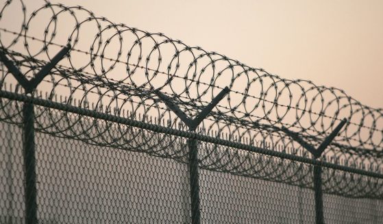 Barbed wire sits a top a fence outside a detention facility in the United States.