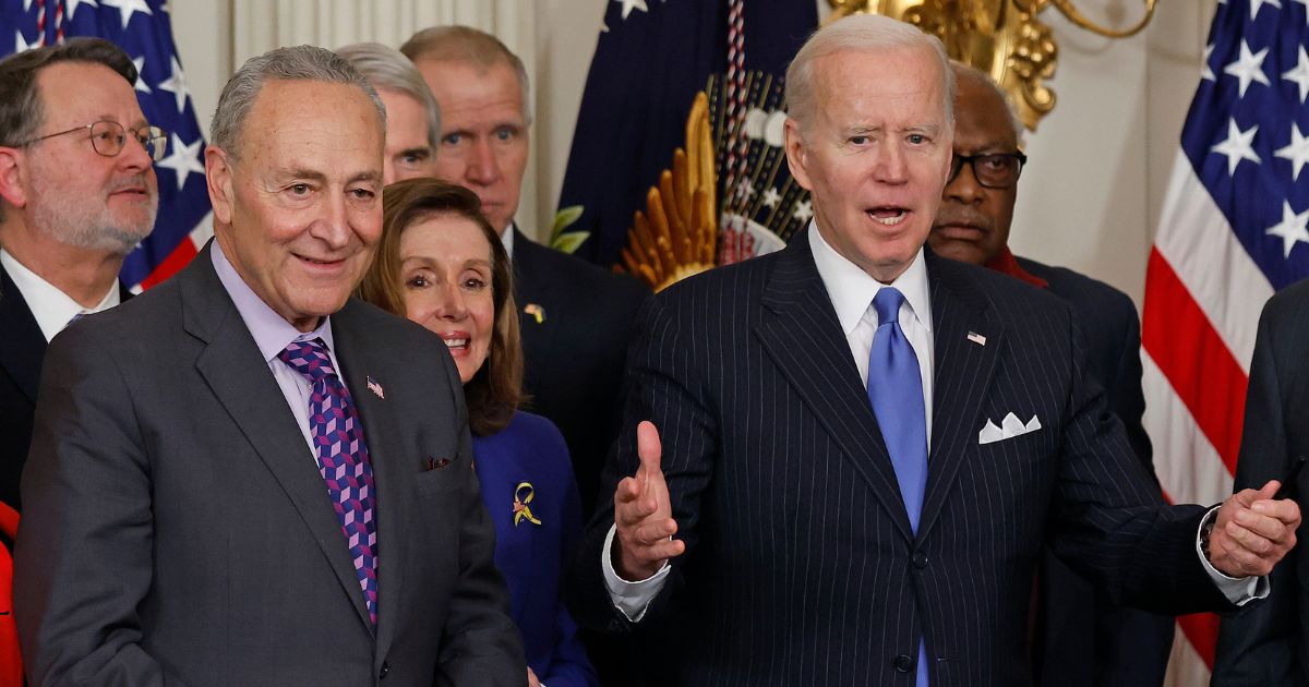 Senate Majority Leader Charles Schumer, left, stands with President Joe Biden and other Democrats during an event in the State Dining Room of the White House in Washington on April 6.