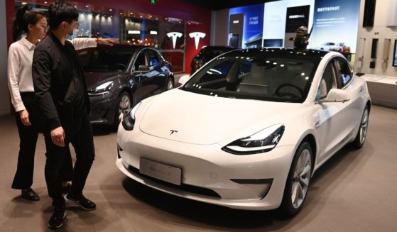 A man looks at a Tesla Model 3 in a showroom in Beijing on Oct. 21, 2020.