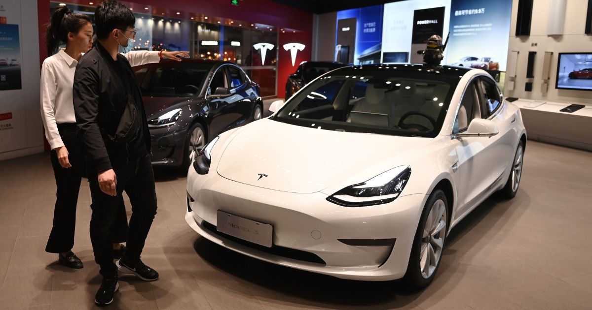 A man looks at a Tesla Model 3 in a showroom in Beijing on Oct. 21, 2020.