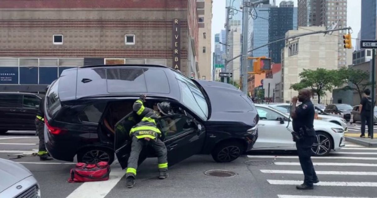 A firefighter in New York City was trapped under an SUV while rescuing a passenger from inside the vehicle.
