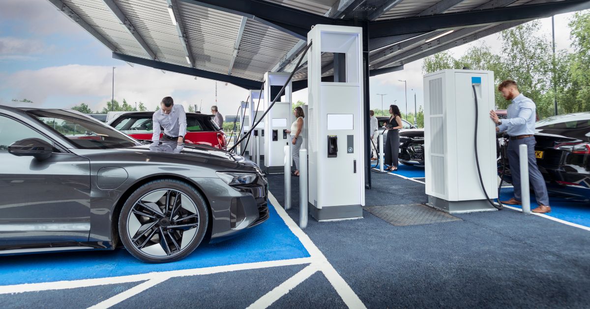 Motorists are shown charging eclectic vehicles at a charging station in the United Kingdom.