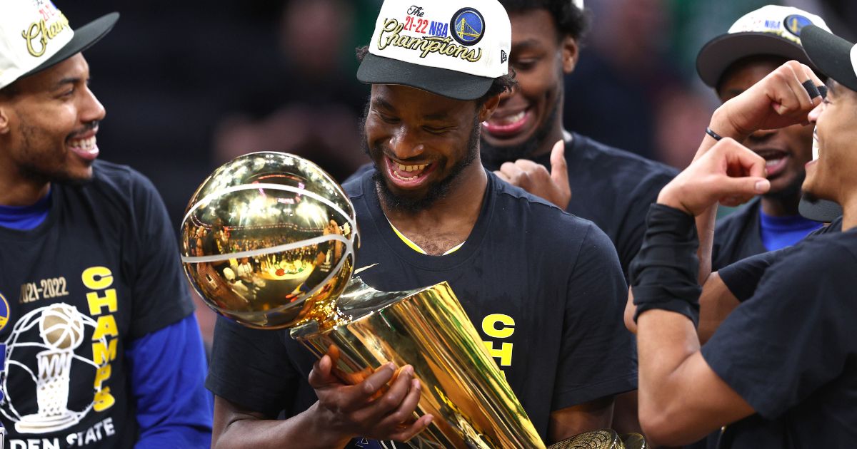 Golden State's Andrew Wiggins celebrates with the Larry O'Brien Championship Trophy after the Warriors defeated the Boston Celtics 103-90 in Game 6 of the NBA Finals at TD Garden in Boston on June 16.