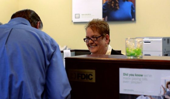 Betty Gonzales, a bank teller in O'Fallon, Missouri, behind her desk