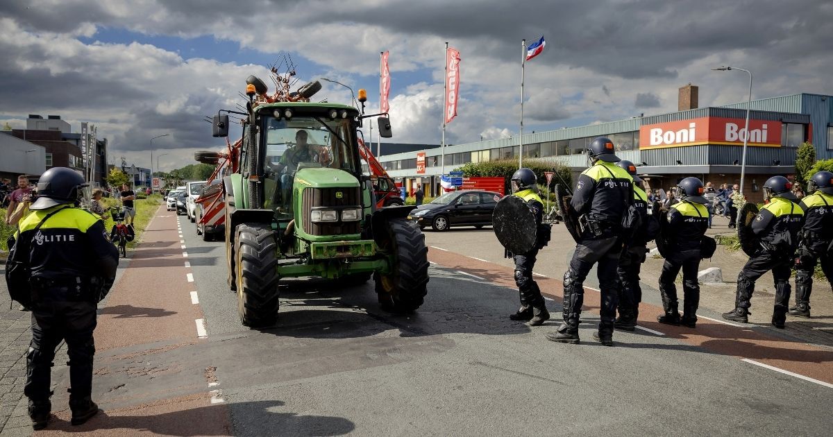 Farmers remove tractors forming a blockade at the police's request at a distribution center of supermarket chain Boni during a demonstration against the Dutch government's plans to cut nitrogen emissions on Tuesday.