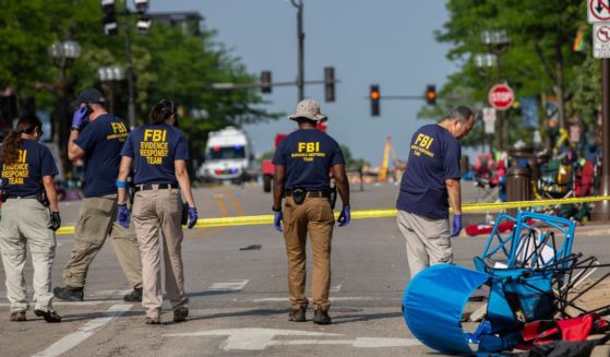 FBI agents investigate the scene of a Monday shooting at a Fourth of July parade in Highland Park, Illinois.