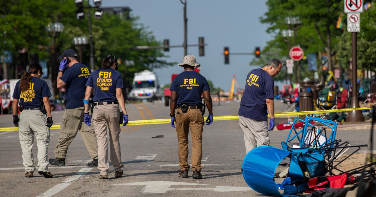 FBI agents investigate the scene of a Monday shooting at a Fourth of July parade in Highland Park, Illinois.