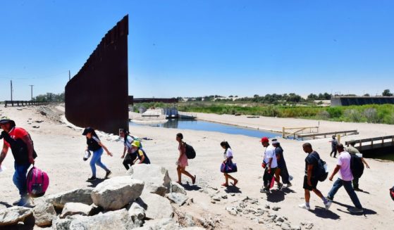 Migrants illegally cross into the U.S. from Mexico through a gap in the border wall separating the Mexican town of Algodones from Yuma, Arizona, on May 16.