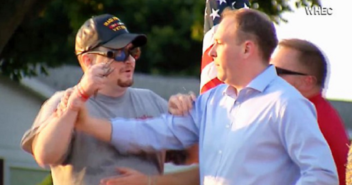 Rep. Lee Zeldin tries to fend off a man during a campaign event Thursday in Fairport, New York.
