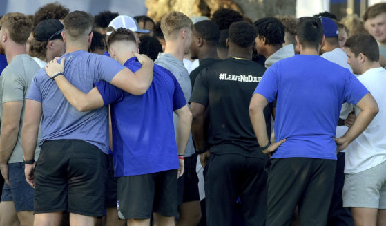 Members of the Indiana State football team console one another after a vigil at Memorial Stadium in Terre Haute on Sunday for students, including fellow football players, who were involved in a car crash earlier in the day.