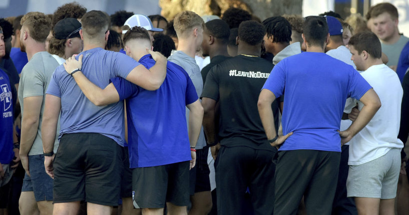 Members of the Indiana State football team console one another after a vigil at Memorial Stadium in Terre Haute on Sunday for students, including fellow football players, who were involved in a car crash earlier in the day.