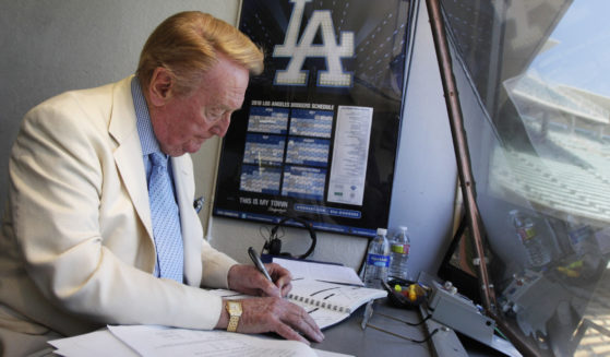 Vin Scully works in his booth at Dodger Stadium in Los Angeles on Aug. 22, 2010. Scully died Tuesday night.