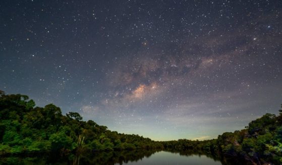 The night sky is illuminated over the Manicore river in the Amazonas state, Brazil, in the Amazon rainforest.