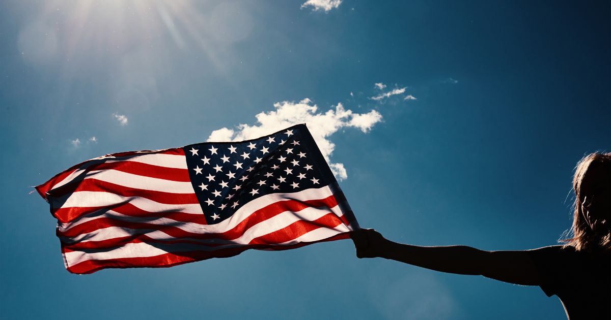 A woman holds an American flag in this stock image.