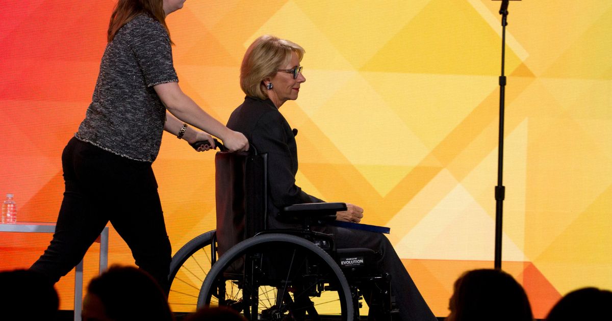 Then-Education Secretary Betsy DeVos leaves the stage in a wheelchair after speaking during the U.S. Conference of Mayors' annual meeting in Washington, D.C., on Jan. 24, 2019.